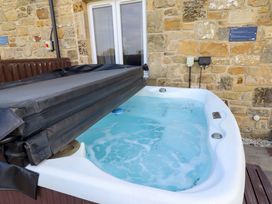 A hot tub with a cover in an outdoor space at Pipistrelle in Bamburgh