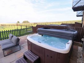 An outdoor area with a hot tub and lounge chair at Pipistrelle in Bamburgh