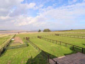 An outdoor area with a fenced space and a view of the sea at Pipistrelle in Bamburgh
