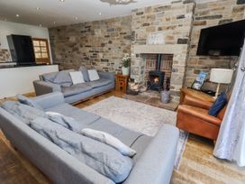 A living room with a fireplace and seating area at Goosander in Bamburgh