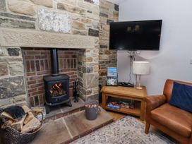 A living room with a fireplace and television at Goosander in Bamburgh