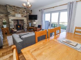 A living room with a fireplace and wooden table at Goosander in Bamburgh