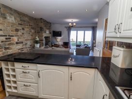 A kitchen with a view of the living area at Goosander in Bamburgh