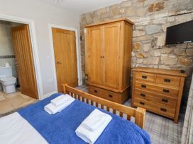 A bedroom with a bed and wardrobe at Goosander in Bamburgh