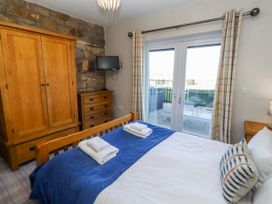 A bedroom with a bed and wardrobe at Goosander in Bamburgh