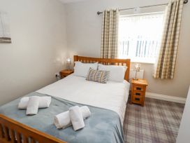 A bedroom with a bed and bedside tables at Goosander in Bamburgh