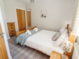 A bedroom with a bed and furniture at Goosander in Bamburgh