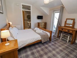 A bedroom with a double bed and a dresser at Goosander in Bamburgh
