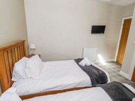 A bedroom with two beds and a television at Goosander in Bamburgh