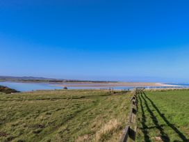 A landscape view with a fence and water at Goosander in Bamburgh