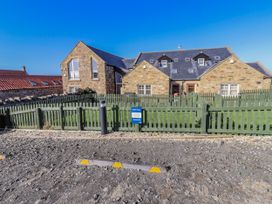 A house with a fence and parking sign at Jackdaw in Bamburgh