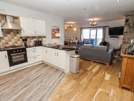 A kitchen with a living room area at Jackdaw in Bamburgh