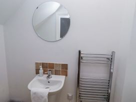 A washbasin and mirror in a bathroom at Jackdaw in Bamburgh