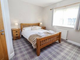 A bedroom with a bed and two bedside tables at Jackdaw in Bamburgh