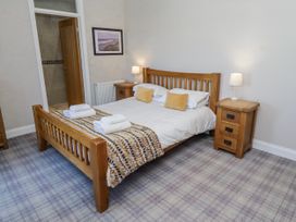 A bedroom with a bed and nightstand at Jackdaw Bamburgh