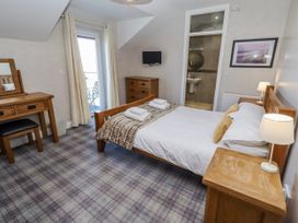 A bedroom with a bed and a dressing table at Jackdaw in Bamburgh