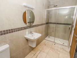 A bathroom with a shower, sink, and toilet at Jackdaw in Bamburgh