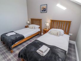 A bedroom with two single beds and a nightstand at Jackdaw in Bamburgh