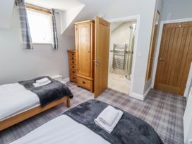 A bedroom with twin beds and a dresser at Jackdaw in Bamburgh
