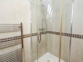 A shower enclosure with tiles and towel rail at Jackdaw in Bamburgh