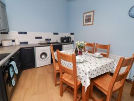 A kitchen with a dining table and chairs at Riverside Cottage in Warkworth