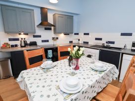 A kitchen with a table setup and appliances at Riverside Cottage Warkworth