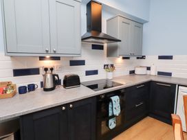 A kitchen with cabinets and appliances at Riverside Cottage in Warkworth