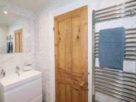 A bathroom with a basin and mirror at Riverside Cottage in Warkworth