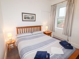 A bedroom with a bed and bedside table at Riverside Cottage in Warkworth