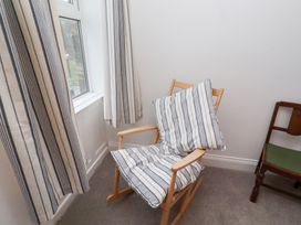A rocking chair with cushions in a sitting room at Riverside Cottage in Warkworth