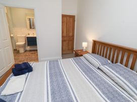 A bedroom with a bed and access to a bathroom at Riverside Cottage Warkworth