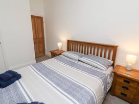 A bedroom with a bed and nightstand at Riverside Cottage Warkworth