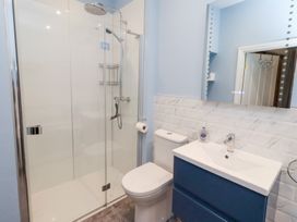 A bathroom with a shower, toilet, and vanity sink at Riverside Cottage in Warkworth