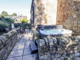 An outdoor area with a hot tub and seating at Old Mill (Lucker) Lucker