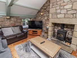 A living room with a sofa and television at Old Mill (Lucker) Lucker