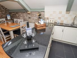 A kitchen with dining table and wine bottle at Old Mill (Lucker) Lucker