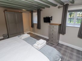 A bedroom with a bed, wardrobe, television and towels at Old Mill (Lucker)