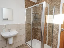 A bathroom with a shower, sink, and mirror at Old Mill (Lucker) Lucker