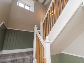 A staircase with wooden banister and window at Old Mill (Lucker) Lucker