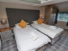 A bedroom with two single beds and a window at Old Mill (Lucker) Lucker