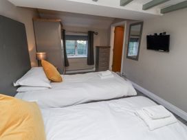A bedroom with two beds and a television at Old Mill in Lucker