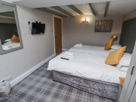 A bedroom with two beds and a television at Old Mill in Lucker