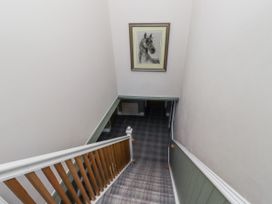 A staircase with a horse portrait and plaid flooring at Old Mill (Lucker)