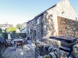 A garden with a dining table and hot tub at Old Mill in Lucker