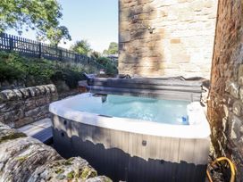 A hot tub in a garden area at Old Mill (Lucker) Lucker