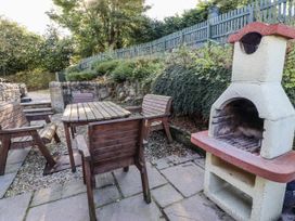 A garden with a table, chairs, and barbecue grill at Old Mill (Lucker) Lucker