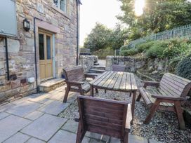 An outdoor seating area with wooden furniture at Old Mill (Lucker) Lucker
