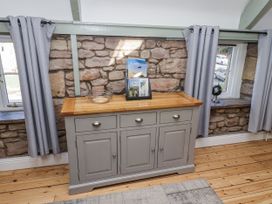 A living room with a cabinet and magazine at Millstone in Lucker