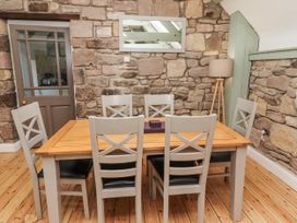 A dining room with a wooden table and chairs at Millstone in Lucker