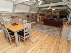 A living room with a dining area and sofa at Millstone in Lucker